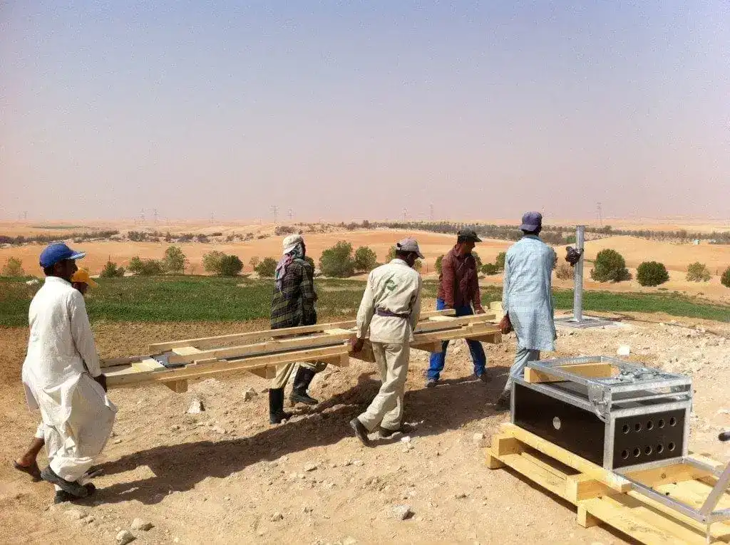 Alt-Text: Männer bauen Wasserspeicher im Wüstenfeld in der Wüstenbegrünung.