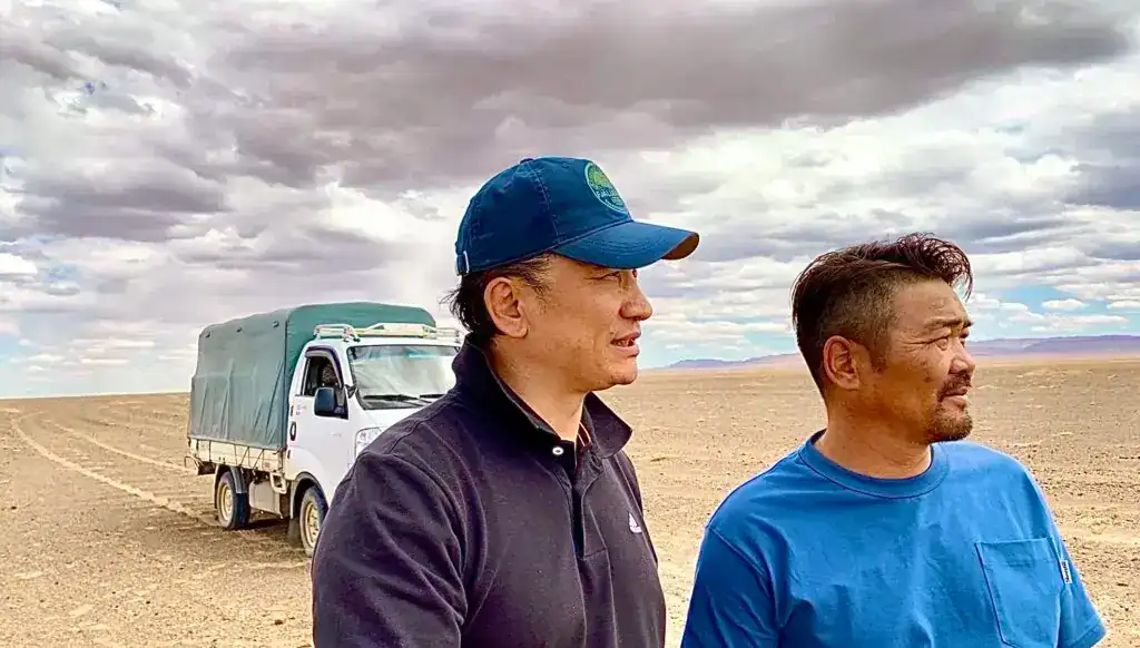 Menschen in der Wüste bei einer Desert-Greening-Projekt im Sonnenlicht.
