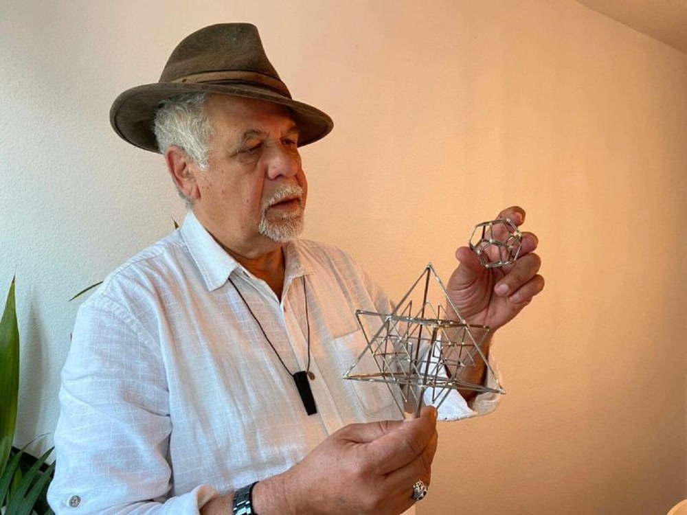 Madjid Abdellaziz hält zwei geometrische Metallmodelle in den Händen