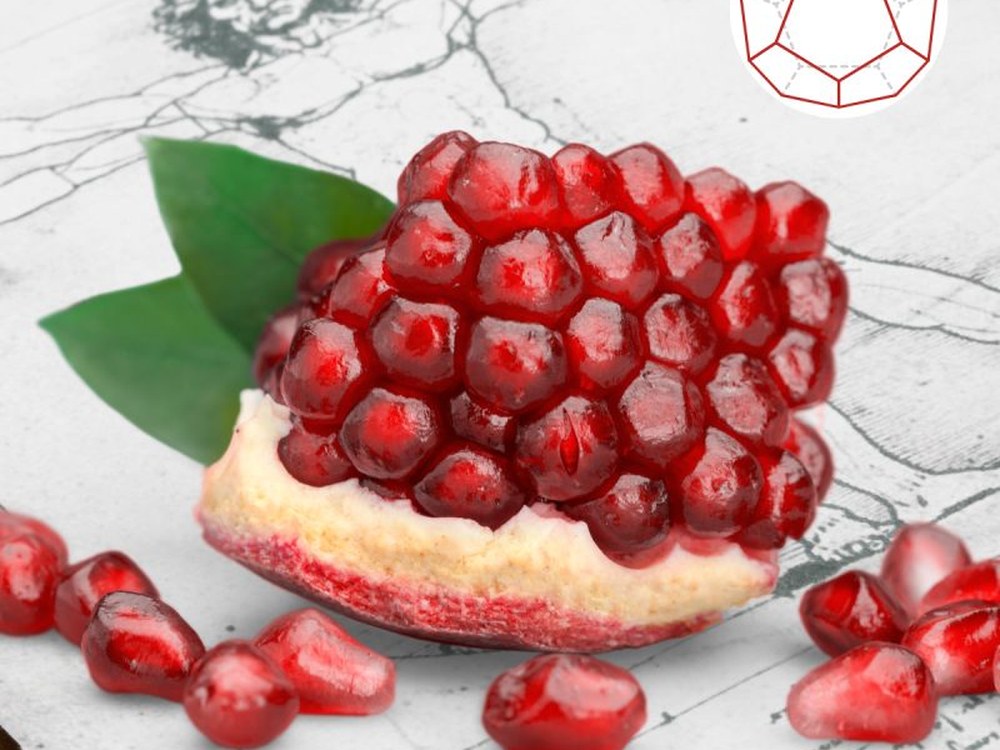 Aufgeschnittener Granatapfel mit Körnern neben einer Dodekaeder-Skizze